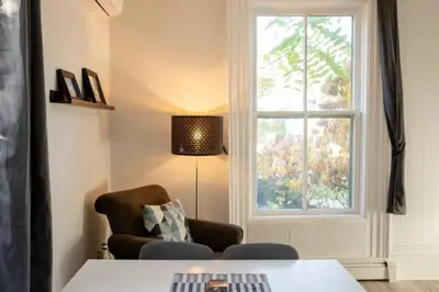 a living room with a table and a window at County Cove - Picton Suite - downtown Wellington in Wellington