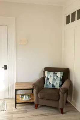 a living room with a chair and a table at County Cove - Picton Suite - downtown Wellington in Wellington