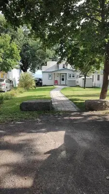 a house with a driveway in front of it at Sakura Cottage - Serenity on PEC Waterfront in Wellington