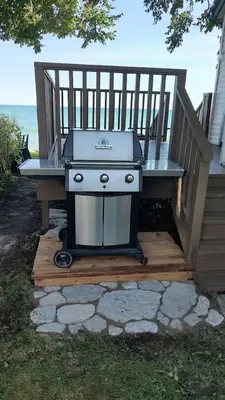 a grill sitting on a bench next to a porch at Sakura Cottage - Serenity on PEC Waterfront in Wellington