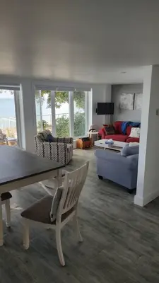 a living room with a couch and a table and chairs at Sakura Cottage - Serenity on PEC Waterfront in Wellington