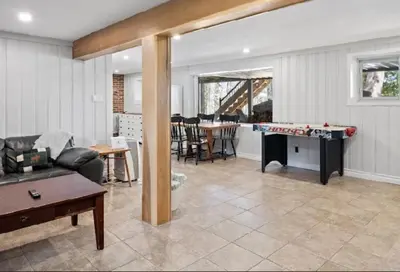 a living room with a couch and a pool table at Muskoka Charm Beautiful four bedroom cottage in Gravenhurst