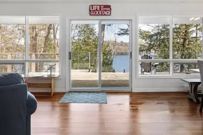 a living room with a door with a sign that reads life benefits at Muskoka Charm Beautiful four bedroom cottage in Gravenhurst
