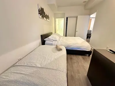 a bedroom with two beds and a desk at Comfy 1Bdrm den 2Baths with 3 real beds plus parking in Toronto