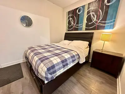 a bedroom with a bed and a clock on the wall at Comfy 1Bdrm den 2Baths with 3 real beds plus parking in Toronto