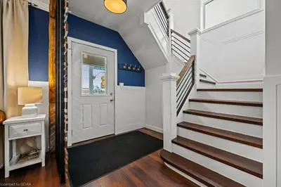 a hallway with blue walls and a white door and stairs at 4 Bedroom Luxury House, Free Parking, Next to LRT, Kitchener Downtown, near Chicopee Ski Club in Kitchener