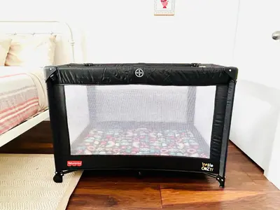 a black crib with a screen in a bedroom at 4 Bedroom Luxury House, Free Parking, Next to LRT, Kitchener Downtown, near Chicopee Ski Club in Kitchener