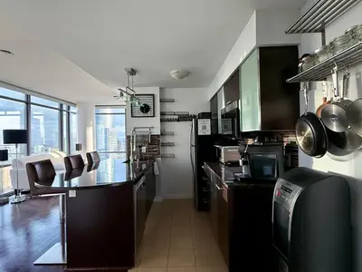 a kitchen with black cabinets and a counter top at 44th Floor, Panoramic Views, Bay Corridor Downtown Toronto Condo in Toronto