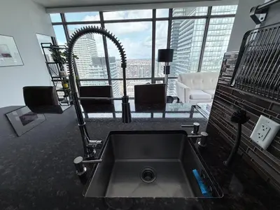 a kitchen sink in a room with a large window at 44th Floor, Panoramic Views, Bay Corridor Downtown Toronto Condo in Toronto