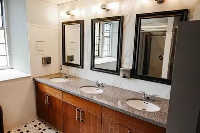 a bathroom with two sinks and two mirrors at Knox Residence - University of Toronto in Toronto
