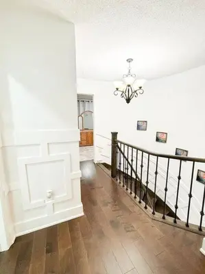 a room with a staircase and a chandelier at Supreme Suites in Ajax