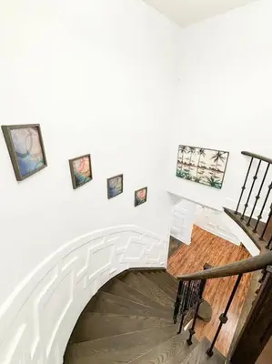 a white staircase with pictures on the wall at Supreme Suites in Ajax