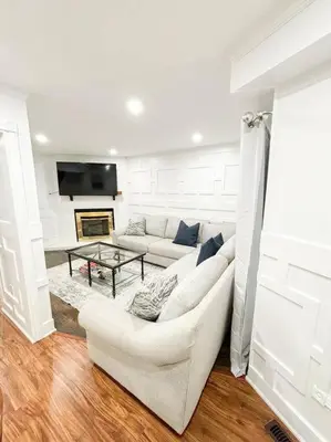 a white living room with a couch and a table at Supreme Suites in Ajax