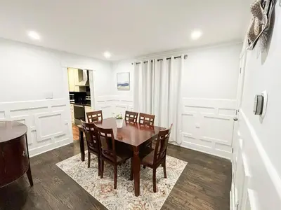 a dining room with a wooden table and chairs at Supreme Suites in Ajax