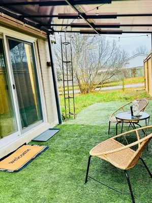 a patio with a table and chairs on the grass at Cozy private backyard garden studio in Pickering