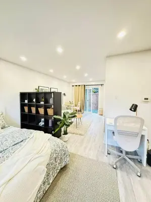 a bedroom with a bed and a desk and a chair at Cozy private backyard garden studio in Pickering