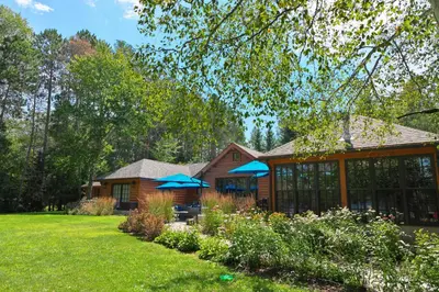 a house with two blue umbrellas in a yard at Haliburton Post House in Minden