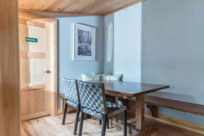 a dining room with a wooden table and chairs at Haliburton Post House in Minden