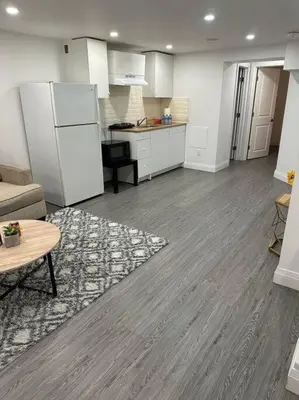 a kitchen with a couch and a table and a refrigerator at One-Bedroom Basement in Oshawa