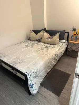 a bed with pillows on it in a room at One-Bedroom Basement in Oshawa