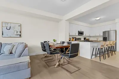 a living room with a table and chairs and a kitchen at Bright & Stylish Modern Townhome in Oakville! in Oakville