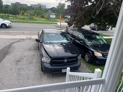 two cars parked in a driveway next to a street at Private Room Near Airport D2 in Brampton