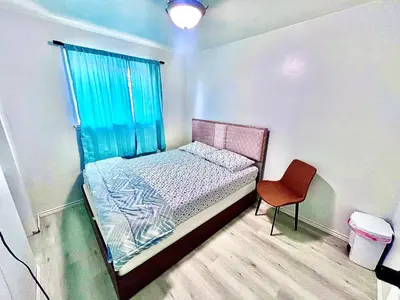 a small bedroom with a bed and a red chair at D3 Room Near Airport in Brampton