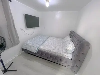 a bed in a room with a tv on the wall at Private Room Near Airport D4 in Brampton