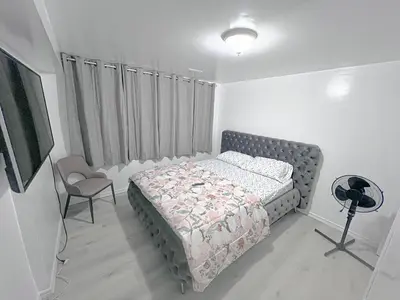 a bedroom with a bed and a tv and a chair at Private Room Near Airport D5 in Brampton