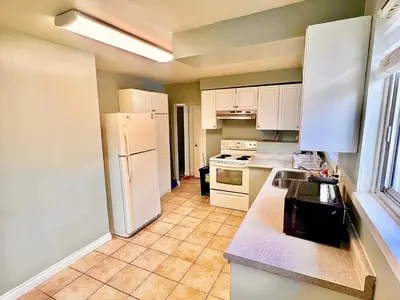 a kitchen with a white refrigerator and white cabinets at Private Room Near Airport D8 in Brampton