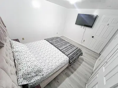a bedroom with a bed and a flat screen tv at Private Room Near Airport D8 in Brampton