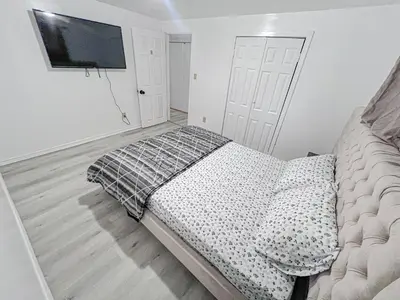 a bedroom with a bed and a flat screen tv at Private Room Near Airport D8 in Brampton