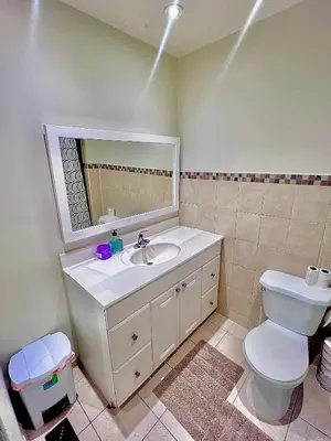 a bathroom with a sink and a toilet and a mirror at Private Room Near Airport D8 in Brampton