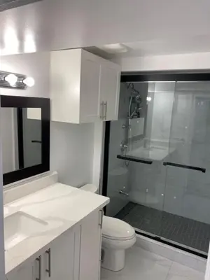 a white bathroom with a shower and a toilet at Adorable 3 Bedroom Apartment with Free Parking in Ajax