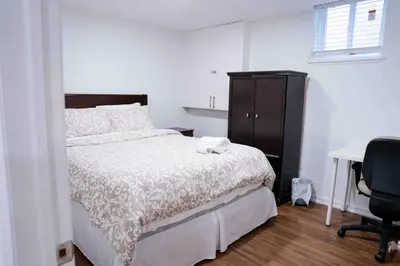 a bedroom with a bed and a desk and a chair at Adorable 3 Bedroom Apartment with Free Parking in Ajax