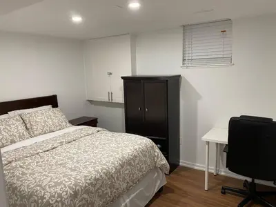 a bedroom with a bed and a desk and a chair at Adorable 3 Bedroom Apartment with Free Parking in Ajax