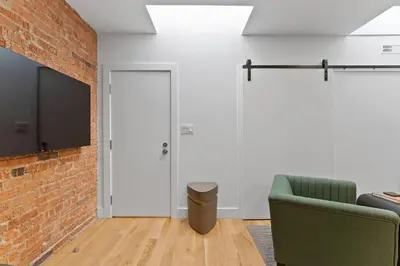 a living room with a brick wall and a green chair at Chic 2BR Top Floor Retreat with Rooftop Near Subway in Toronto
