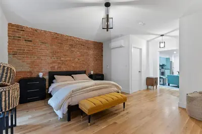 a bedroom with a bed and a brick wall at Chic 2BR Top Floor Retreat with Rooftop Near Subway in Toronto