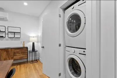 a white laundry room with two washer and dryer at Chic 2BR Top Floor Retreat with Rooftop Near Subway in Toronto