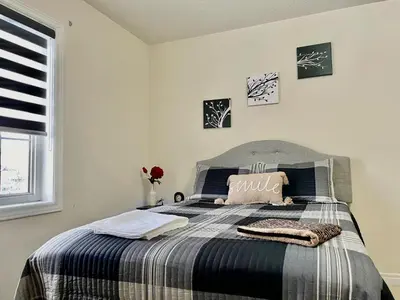 a bedroom with a bed with a striped blanket at Extended Stays Home in Markham