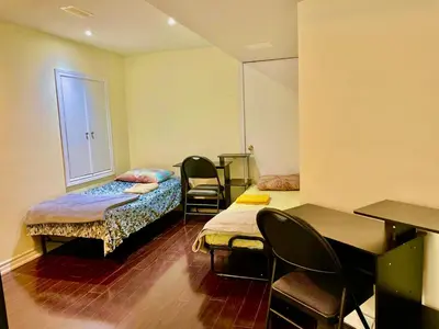 a room with two beds and a table and chairs at Extended Stays Home in Markham