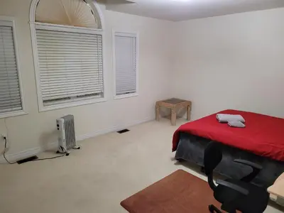a bedroom with a red bed and two windows at Extended Stays Home in Markham