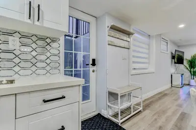 a kitchen with white cabinets and a large window at Luxurious Unit in Hyde Park in London