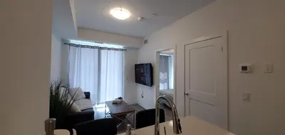 a living room with a couch and a kitchen with a sink at 1 Bedroom condo with balcony Erb St Waterloo in Waterloo