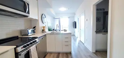 a kitchen with white cabinets and a stove top oven at 1 Bedroom condo with balcony Erb St Waterloo in Waterloo