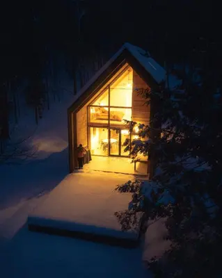a small cabin in the snow at night at Camp Haliburton - Waterfront A-Frame in Wilberforce