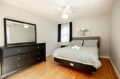 a bedroom with a bed with a dresser and a mirror at Charming 4BR Barrie Retreat with Backyard in Barrie
