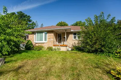 a house with a grassy yard at Charming 4BR Barrie Retreat with Backyard in Barrie