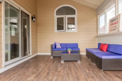 a porch with two blue couches and a table at Barrie Bliss 3BR Haven near Centennial Beach in Barrie
