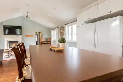 a kitchen with a large wooden table in a room at Barrie Bliss 3BR Haven near Centennial Beach in Barrie